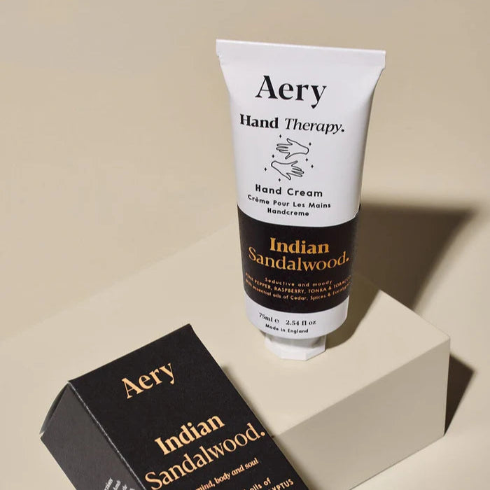 Aery Indian Sandalwood Hand Cream packaging and tube, with white and black color scheme and text detailing.