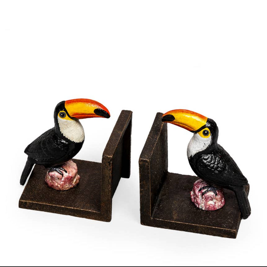 Two toucan figurines on stands with a white background