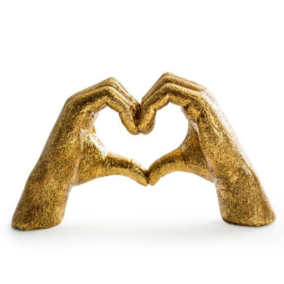 Gold sculpture of two hands forming a heart shape on a white background